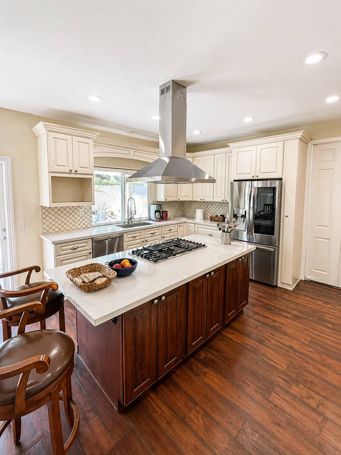 Cream kitchen with island seating and hardwood floors
