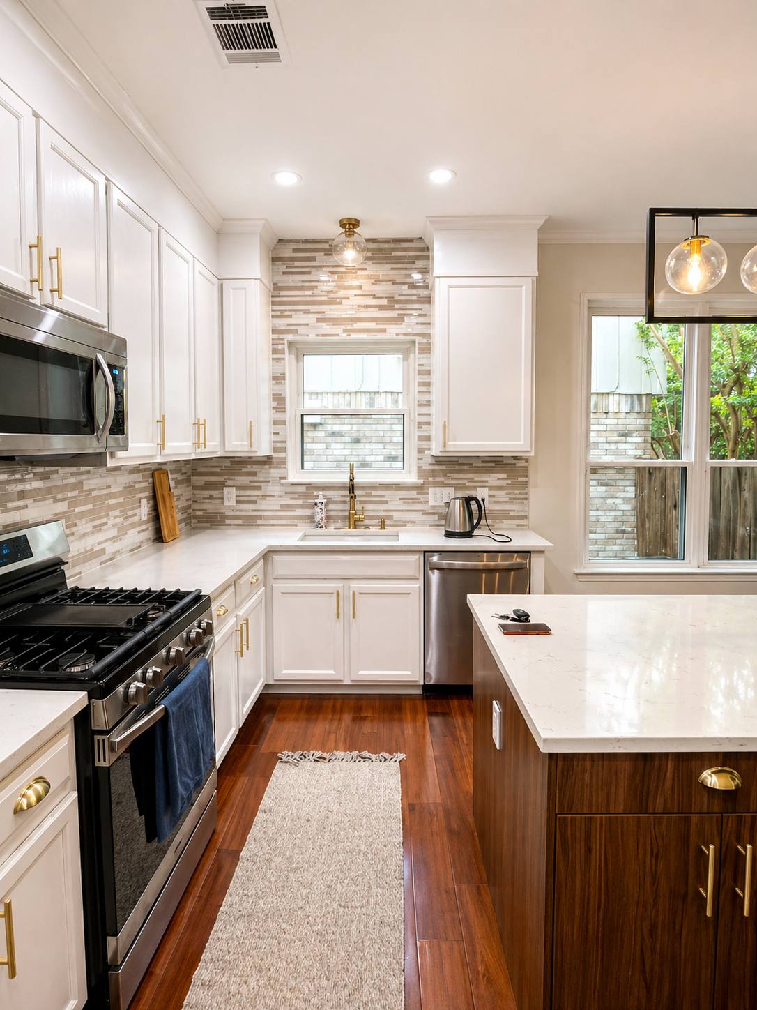 White kitchen with wood island and brass hardware
